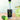 Monin Cucumber syrup bottle with a glass of cucumber slices in water on a wooden surface.