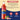 A bottle of Torani Guava syrup on a beige and dark blue graphic background with ingredient text, a plastic PET bottle icon, and a natural 100% badge.