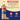 A bottle of Torani English Toffee syrup with a beige label and clear cap, shown on a split beige and dark blue background with ingredient text and feature icons.